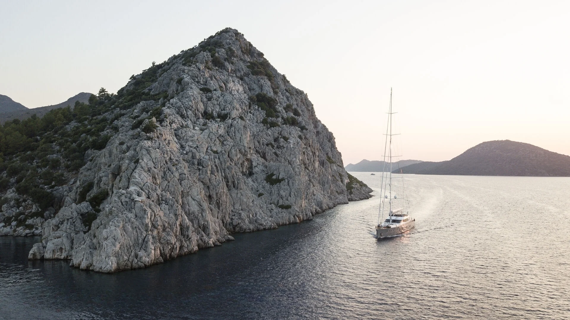 50m motor sailer anchored beside a headland on the Turkish Riviera — crewed superyacht charter AA5019
