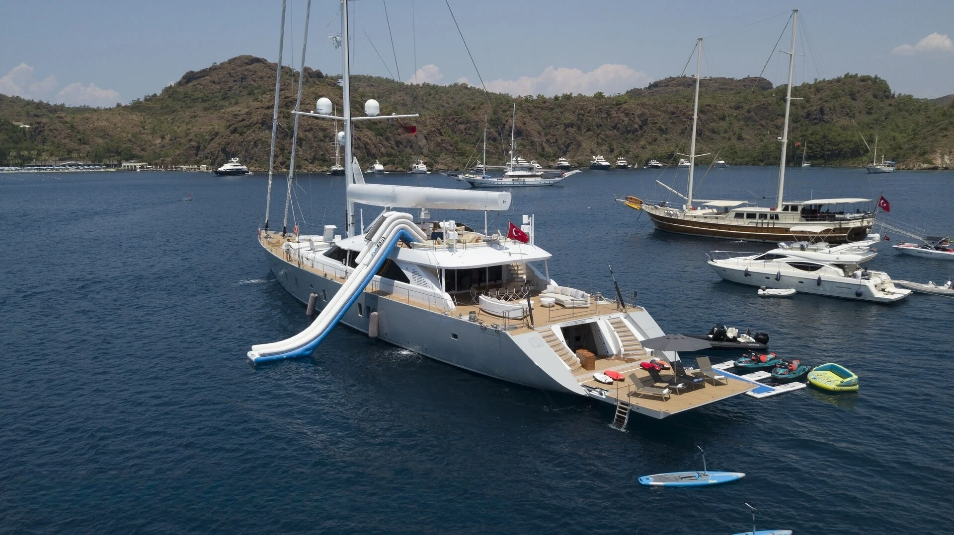 50m motor sailer at anchor with slide and water toys, Bodrum — superyacht charter AA5019