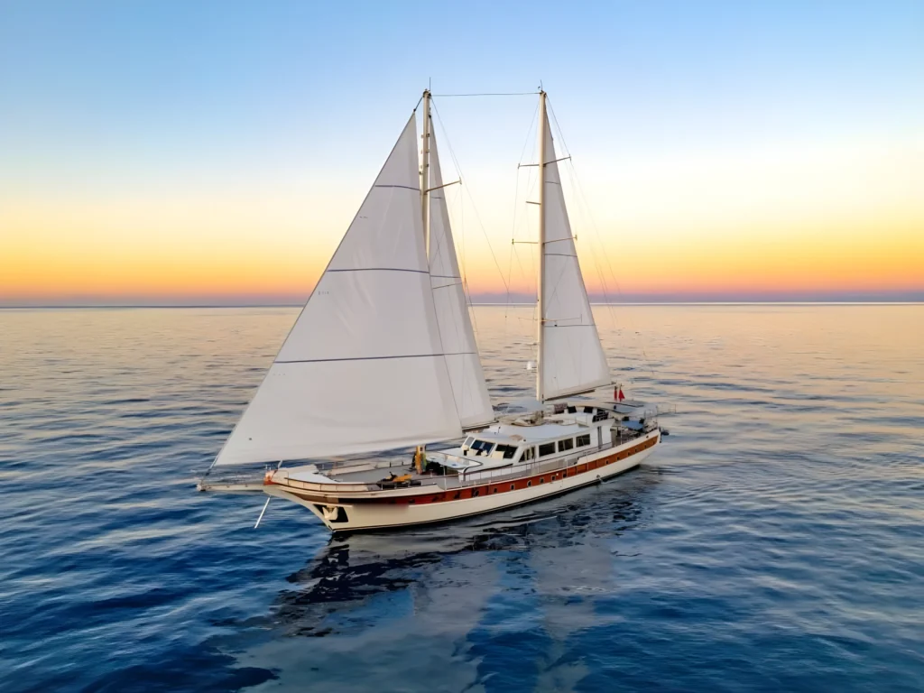 39.6m crewed gulet charter Bodrum vessel under sail at sunset in the Aegean