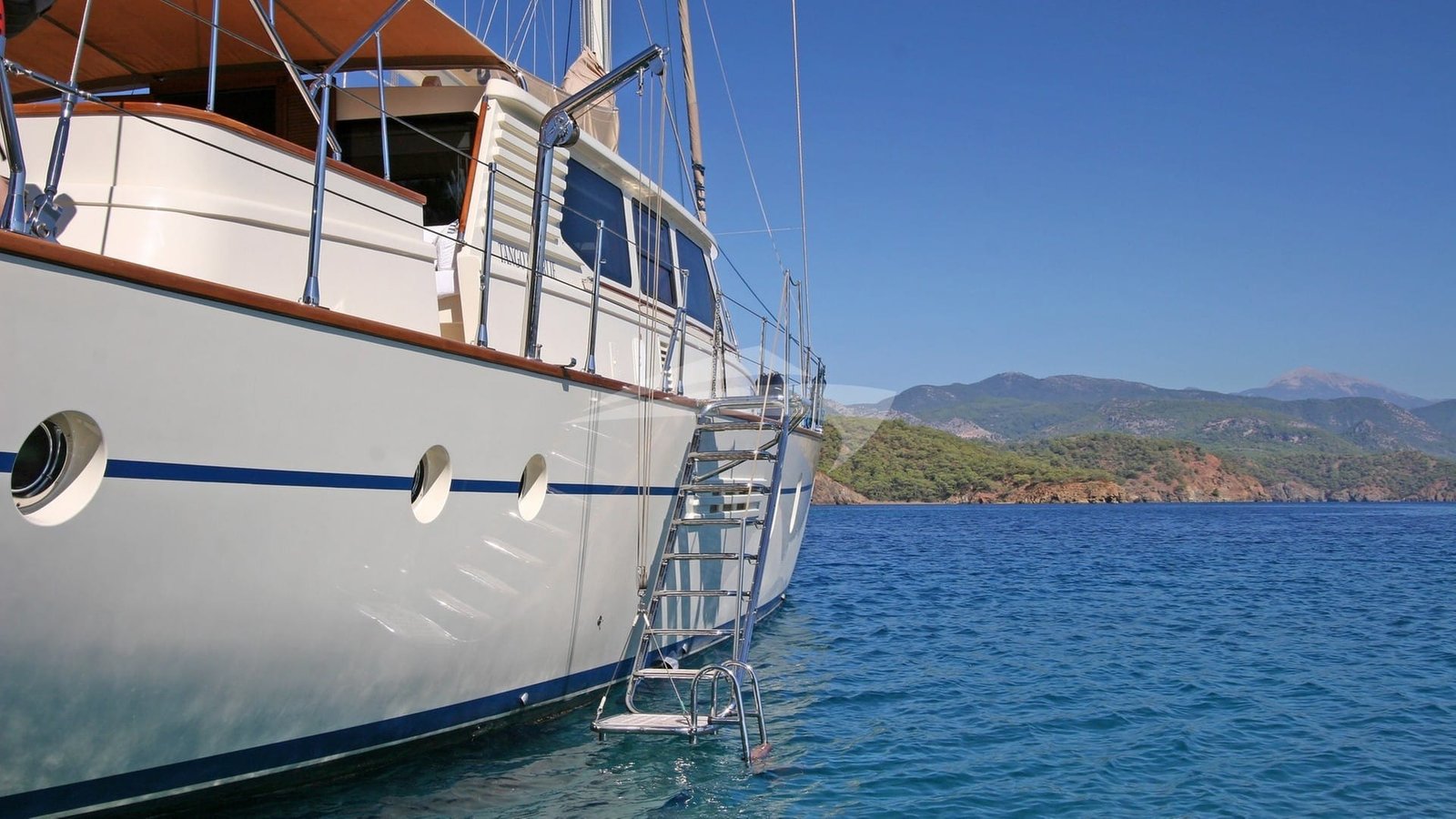 Starboard profile and raised deckhouse of a crewed sailing yacht charter in Bodrum