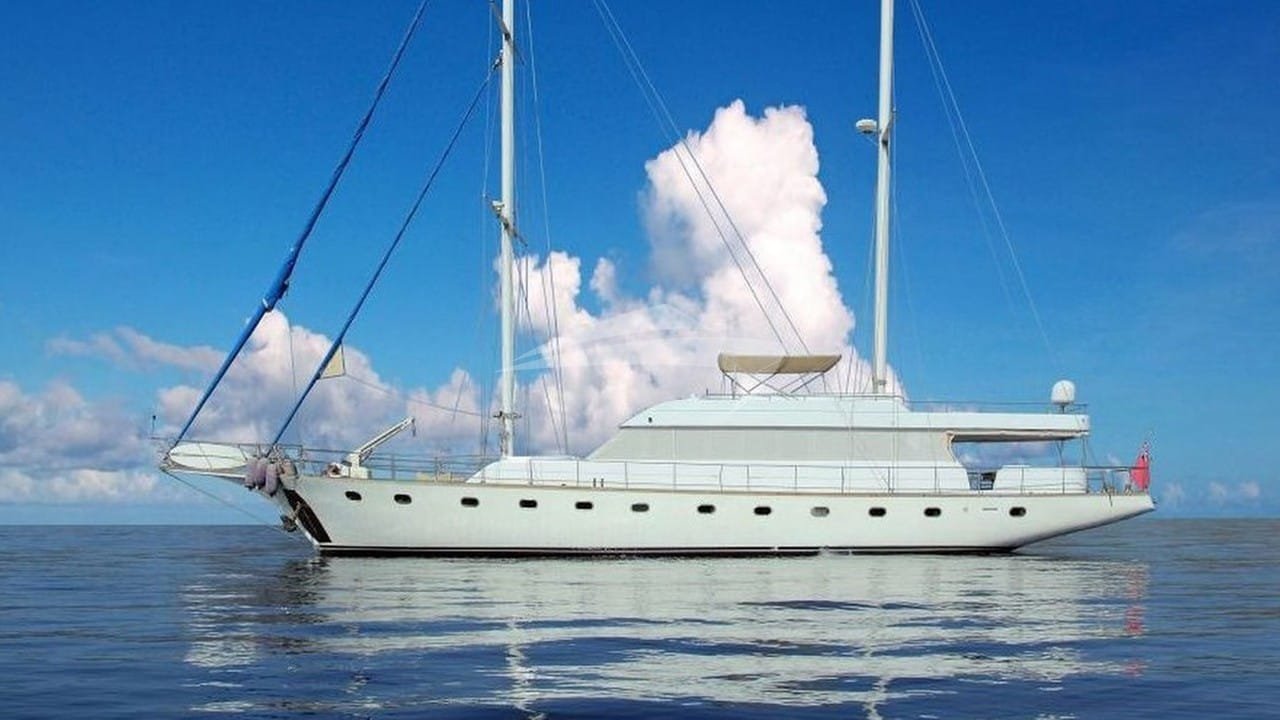 Crewed yacht charter Bodrum - 27m white-hulled motor yacht at anchor under towering cloud
