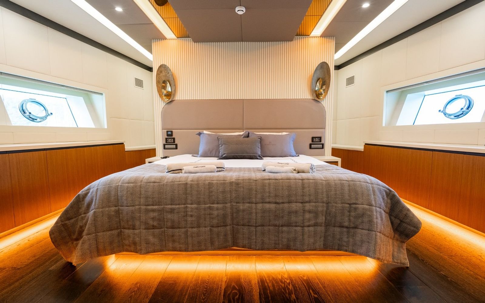 Full-beam master cabin with upholstered headboard aboard a luxury sailing yacht charter in Turkey