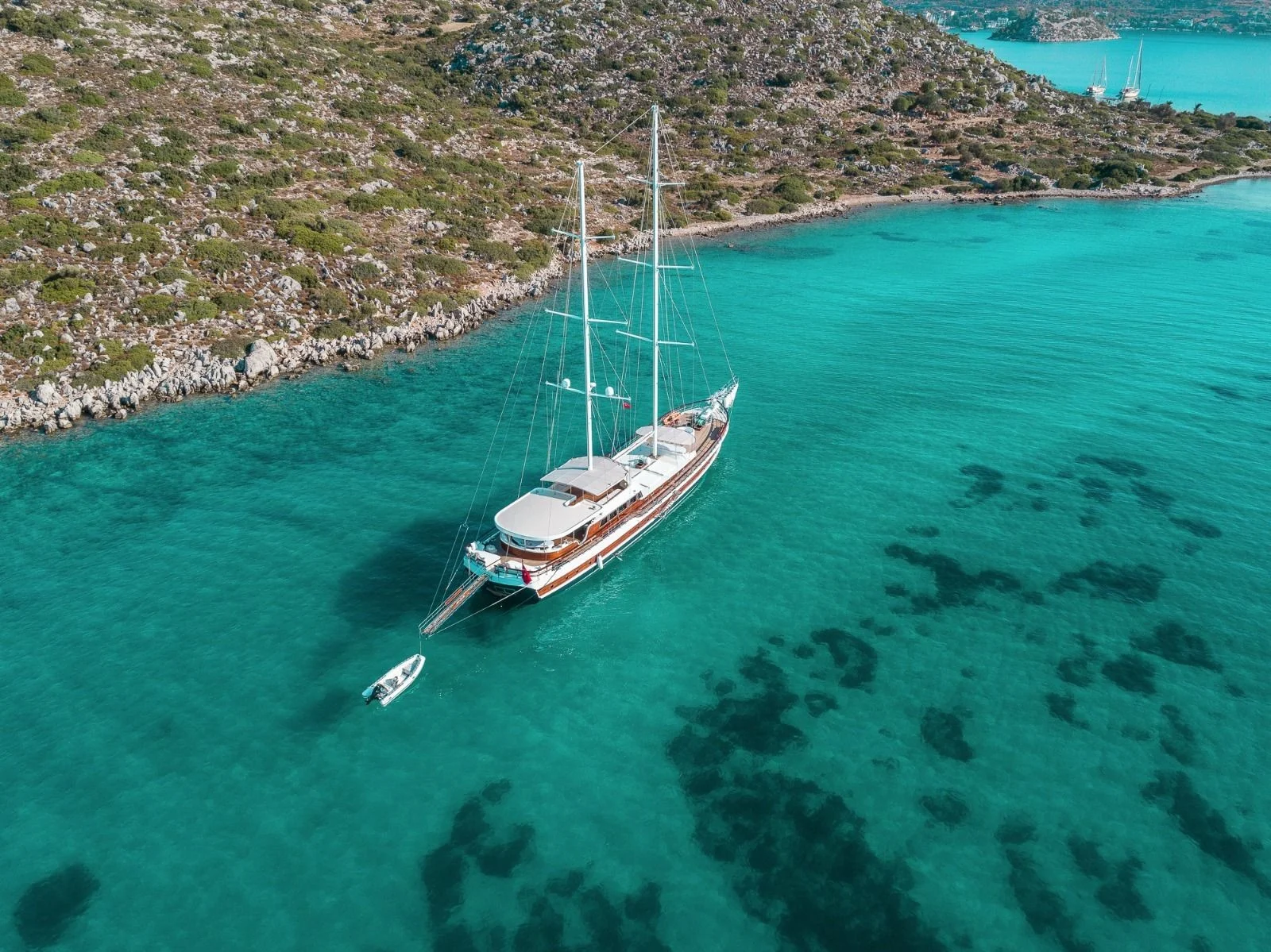 Aerial of a 42m gulet in a turquoise bay with tender, Turkish Riviera charter — HM4218
