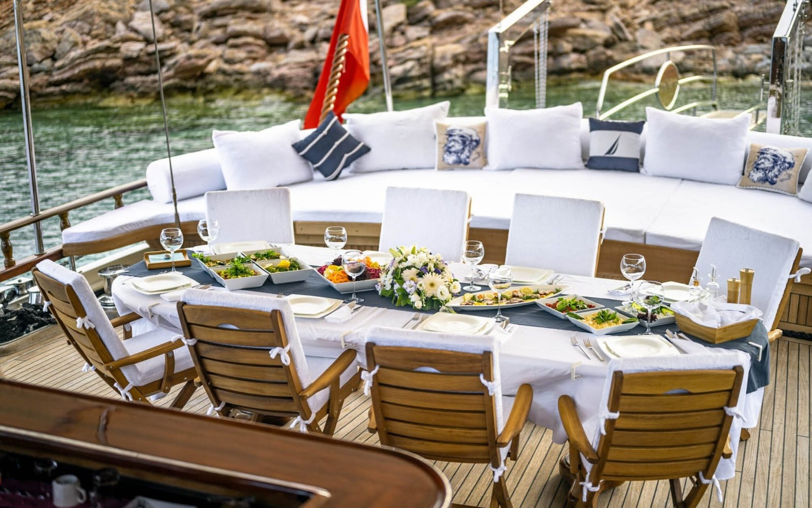 Aft deck dining table dressed with flowers aboard a 30m gulet charter — ED3011