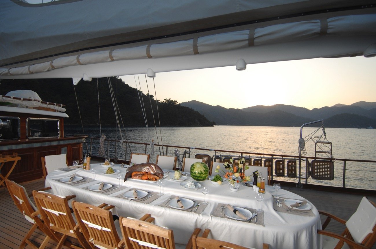 Aft deck dinner service at sunset aboard a crewed 43m motor sailer charter, Turkey — MN4308
