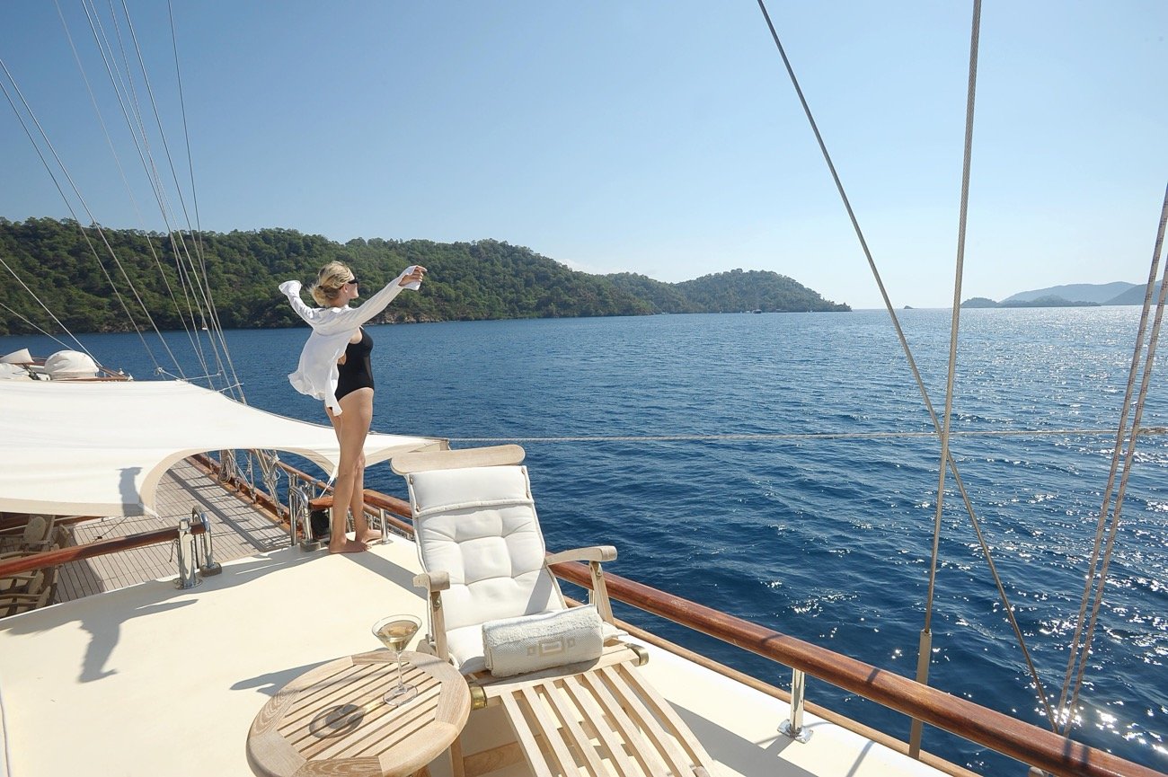 Guest on the foredeck sun pads of a 43m crewed motor sailer charter yacht — MN4308
