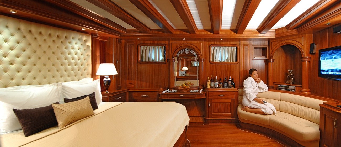 Guest cabin with king bed and seating aboard a 43m six-cabin motor sailer charter — MN4308