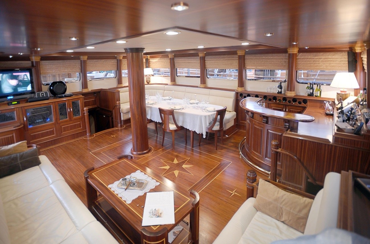 Main saloon with dining table and bar aboard a 43m luxury motor sailer charter — MN4308
