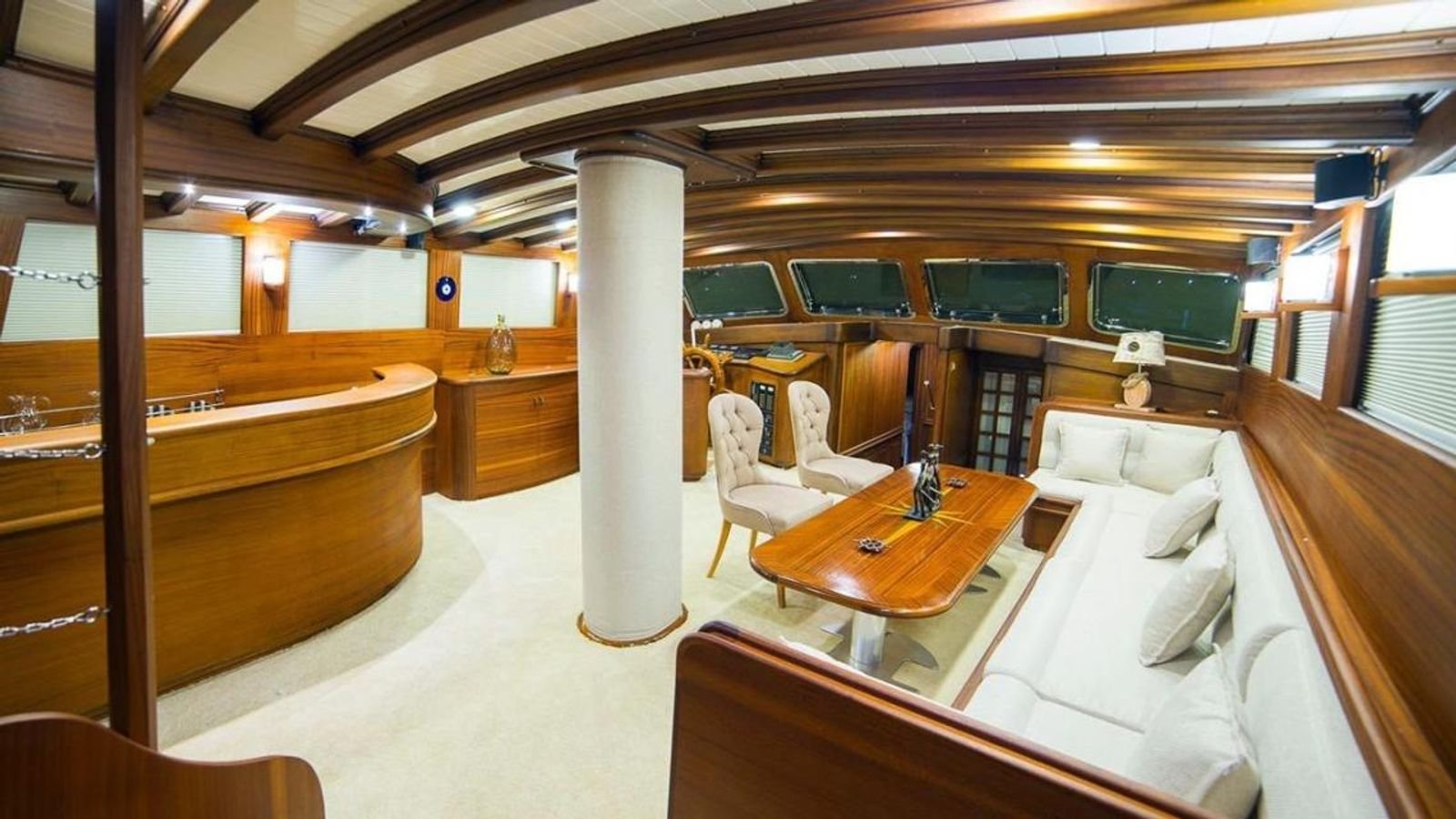 Saloon with a mahogany bar and white upholstery on a traditional gulet charter Bodrum vessel