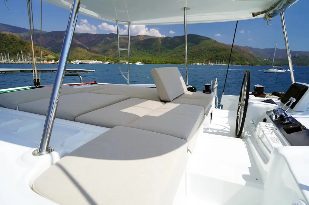 Flybridge sunpads and wheel of a Lagoon 46 catamaran charter in Marmaris under the bimini
