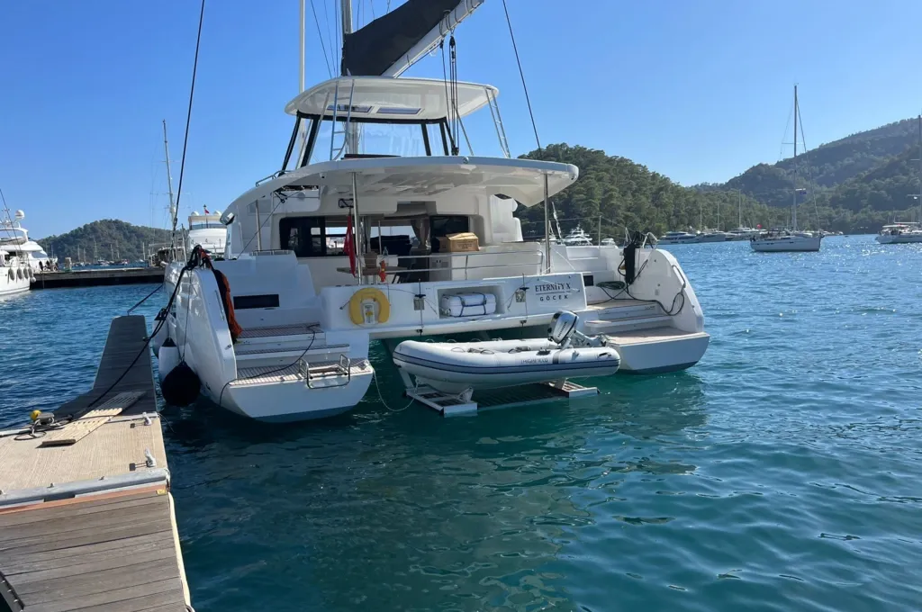 Side profile of the Lagoon 46 charter catamaran on her berth at Gocek, flybridge bimini rigged