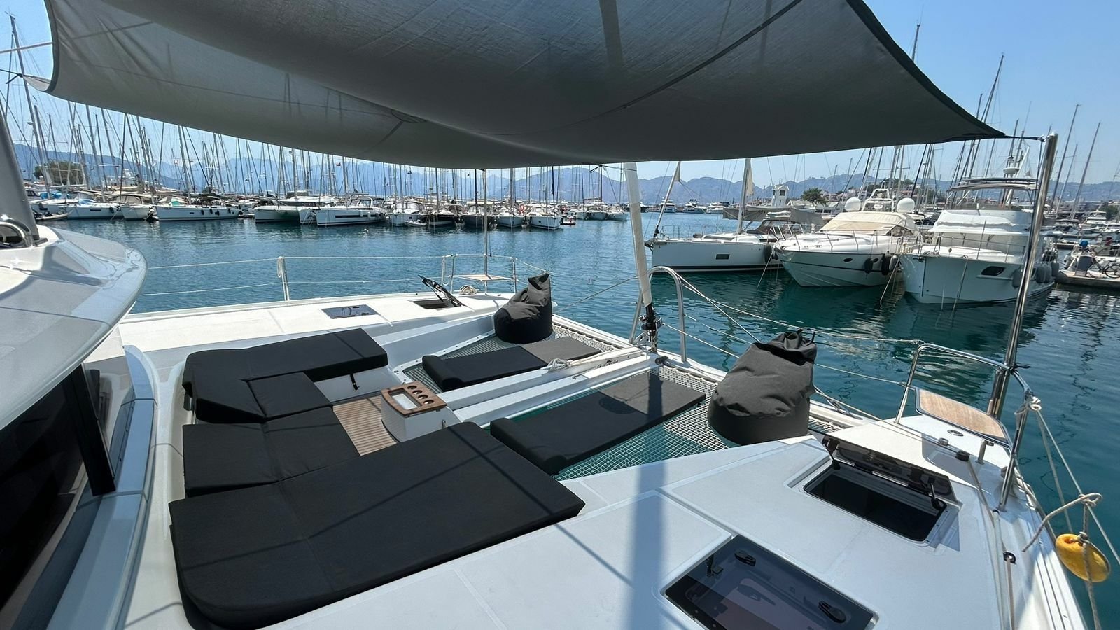 Marmaris'te kiralanan Lagoon 51 katamaranında ön tarafta bulunan salon ve güneşlenme minderleri.