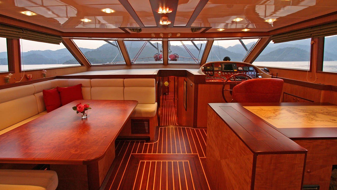 Main saloon with cherry joinery and panoramic windows aboard a 26m motor sailer