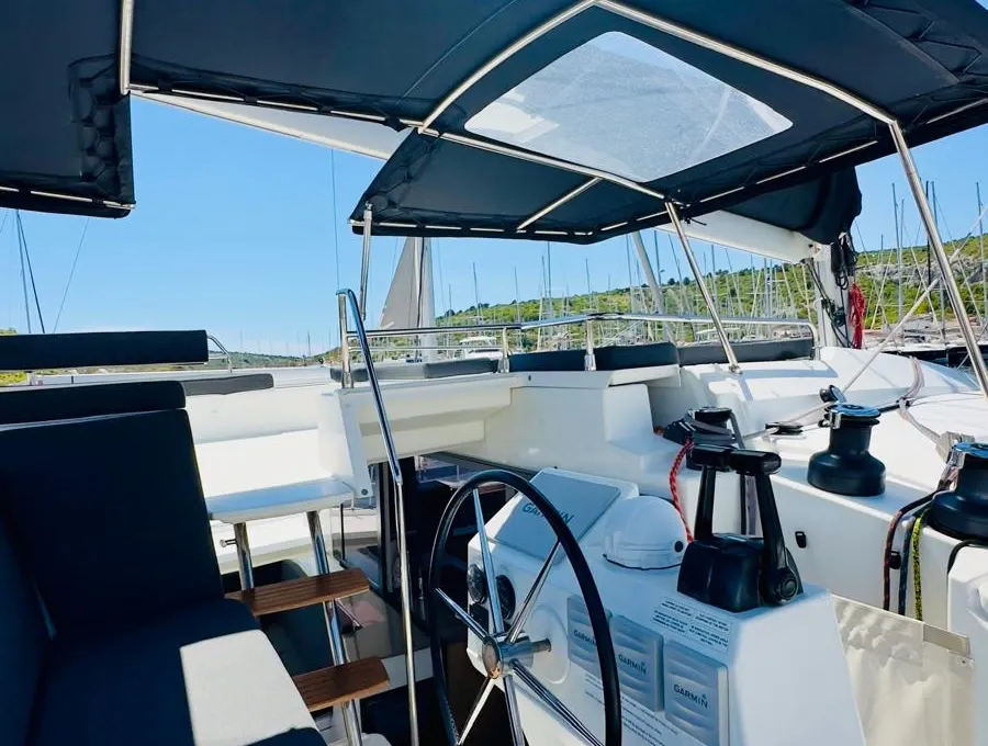 Fethiye'de kiralanan bir Saba 50 katamaranının flybridge dümen konsolu, dümen ve göstergeler tente altında.