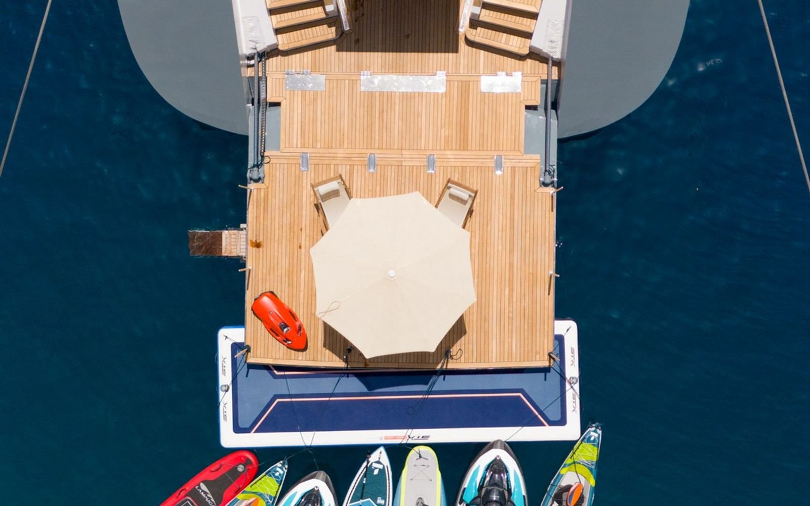 Sundeck, shaded loungers and water toys seen from above on a luxury sailing yacht charter