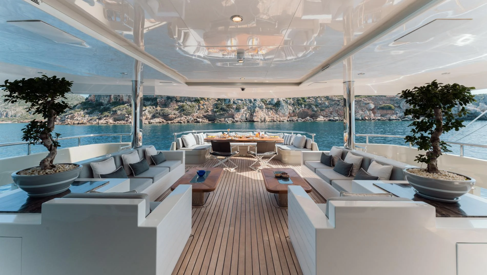 Aft deck lounge with bonsai and teak decking aboard a 47m luxury superyacht charter — OS4712