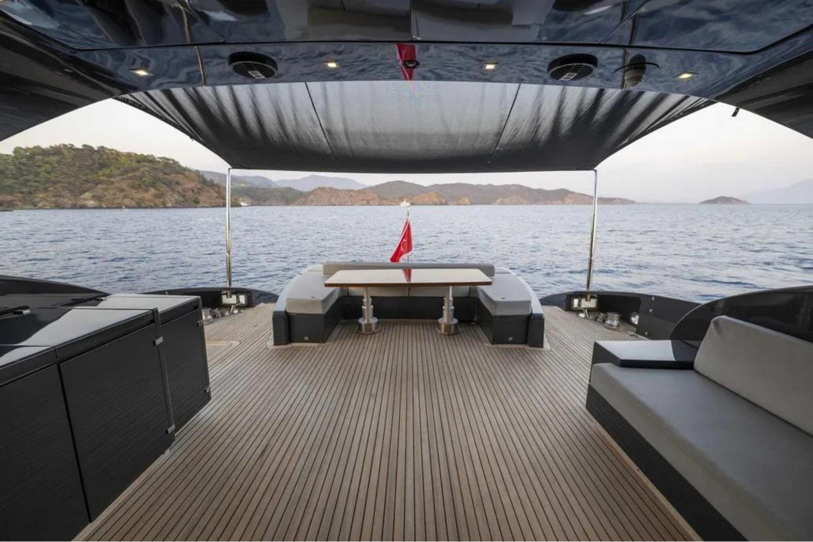 Shaded aft cockpit with dining table and seating on an AB Yachts 92 charter Göcek