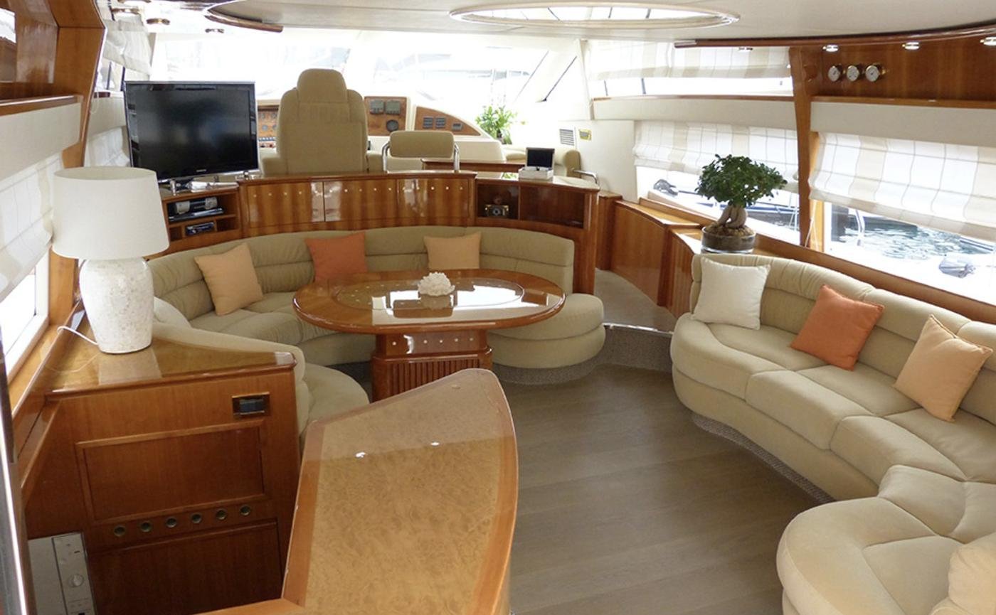 Main saloon with curved settee and lower helm aboard an Azimut 58