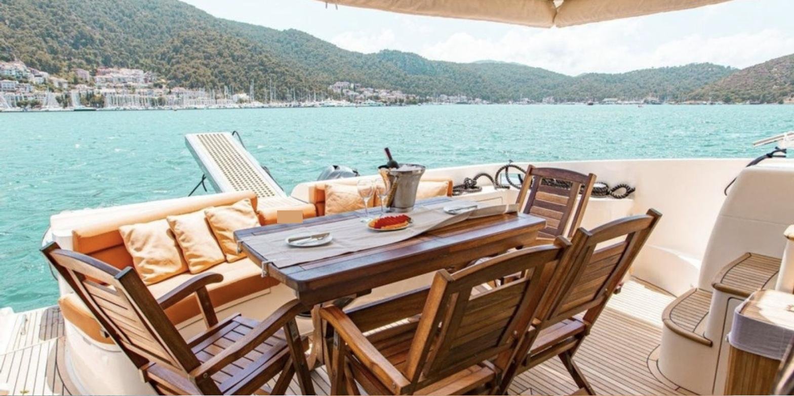 Göcek'te kiralık Azimut 62 Fly'da kıç güvertede açık hava yemeği