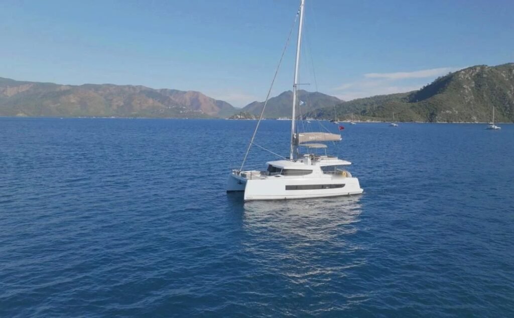 Bali 4.6 charter Marmaris — the catamaran anchored off the pine-clad coast