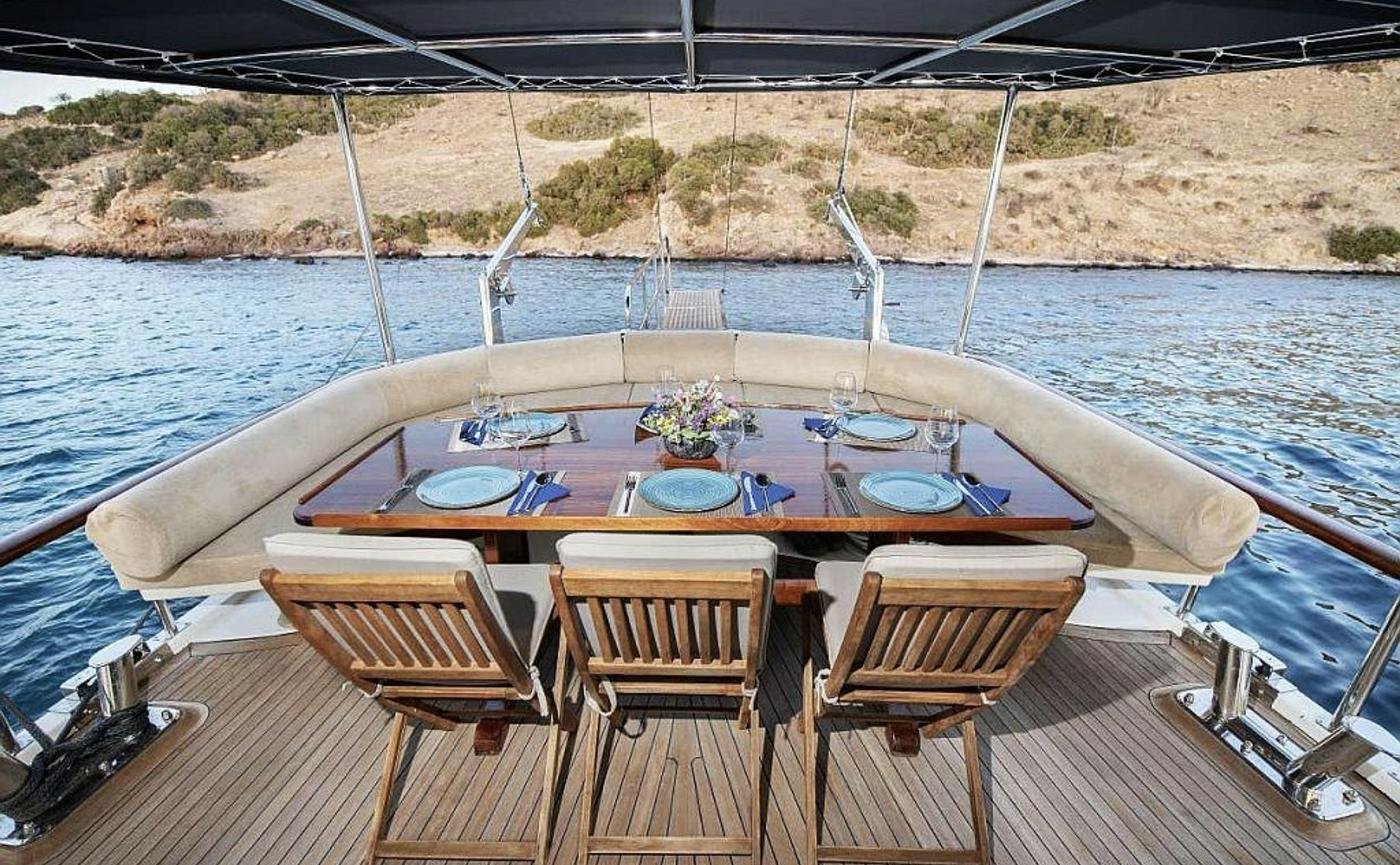 Boutique gulet charter Bodrum - aft deck teak table laid for lunch at anchor