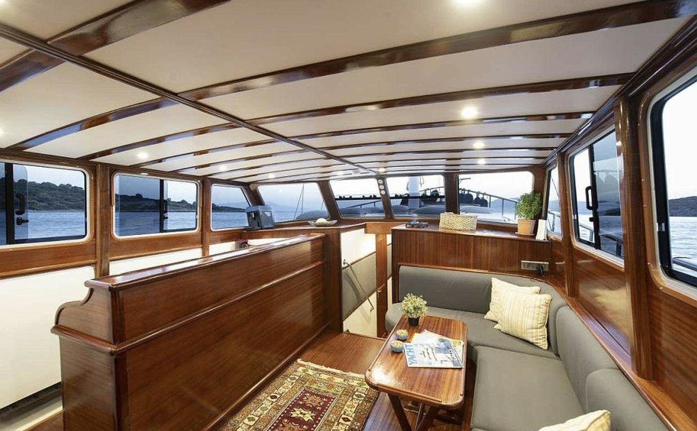 Boutique gulet charter Bodrum - deck saloon panelled in varnished mahogany with sea views