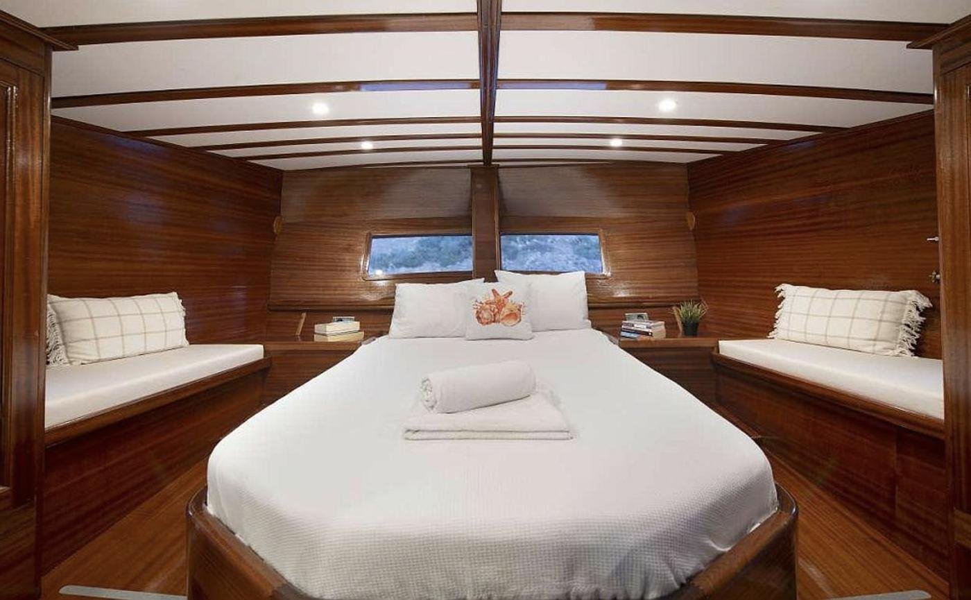 Boutique gulet charter Bodrum - master cabin with a full-beam berth and flanking day settees