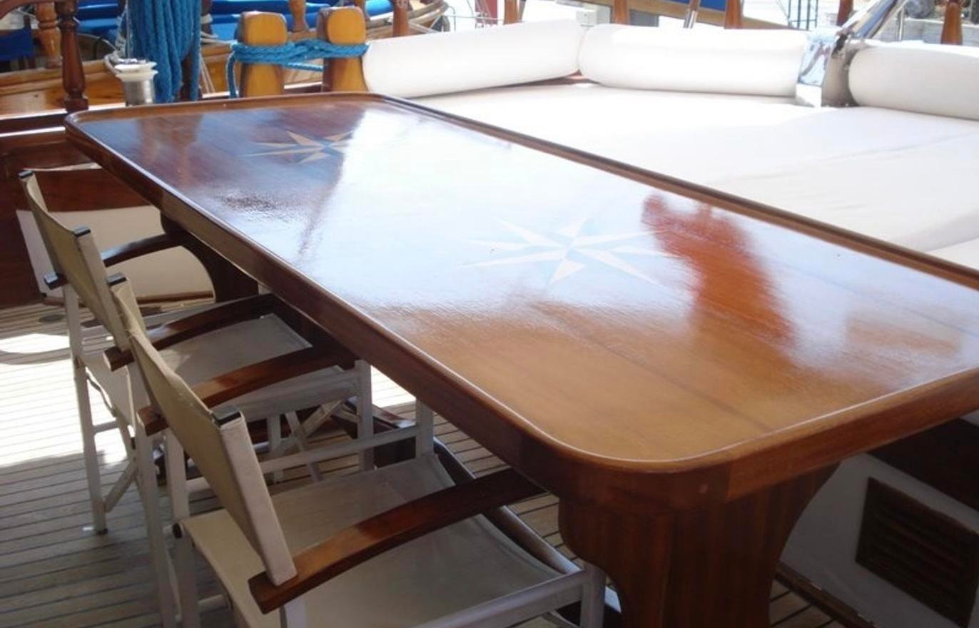 Boutique gulet charter Fethiye - aft deck dining table with compass rose inlay set for lunch