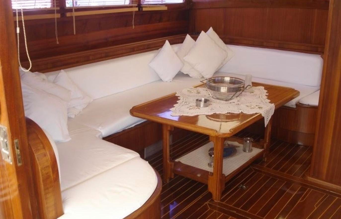 Boutique gulet charter Fethiye - main saloon with corner banquette seating and timber joinery