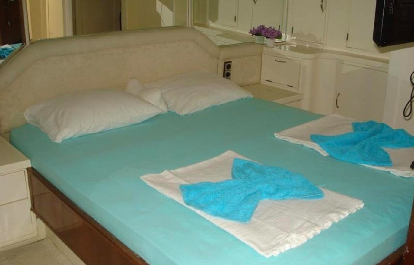 Boutique gulet charter Fethiye - master cabin with upholstered headboard and reading lights