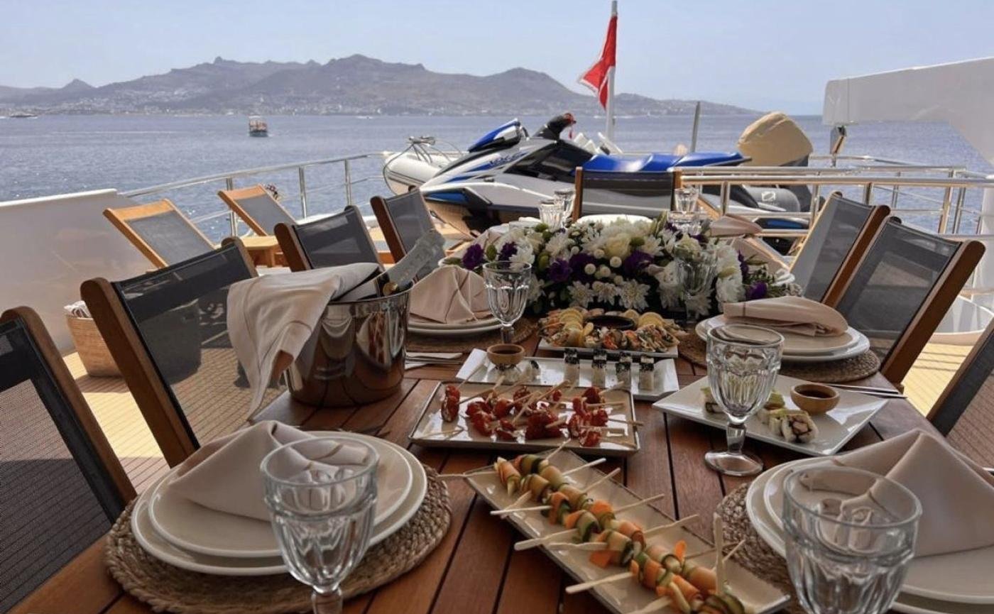 Broward 125 charter Bodrum - aft deck table set with Turkish mezze and jet skis astern