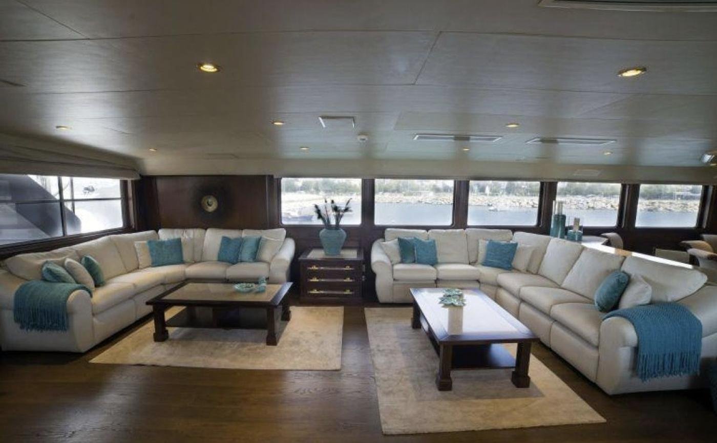 Broward 125 charter Bodrum - full-beam main saloon with twin sofa groups and teal accents