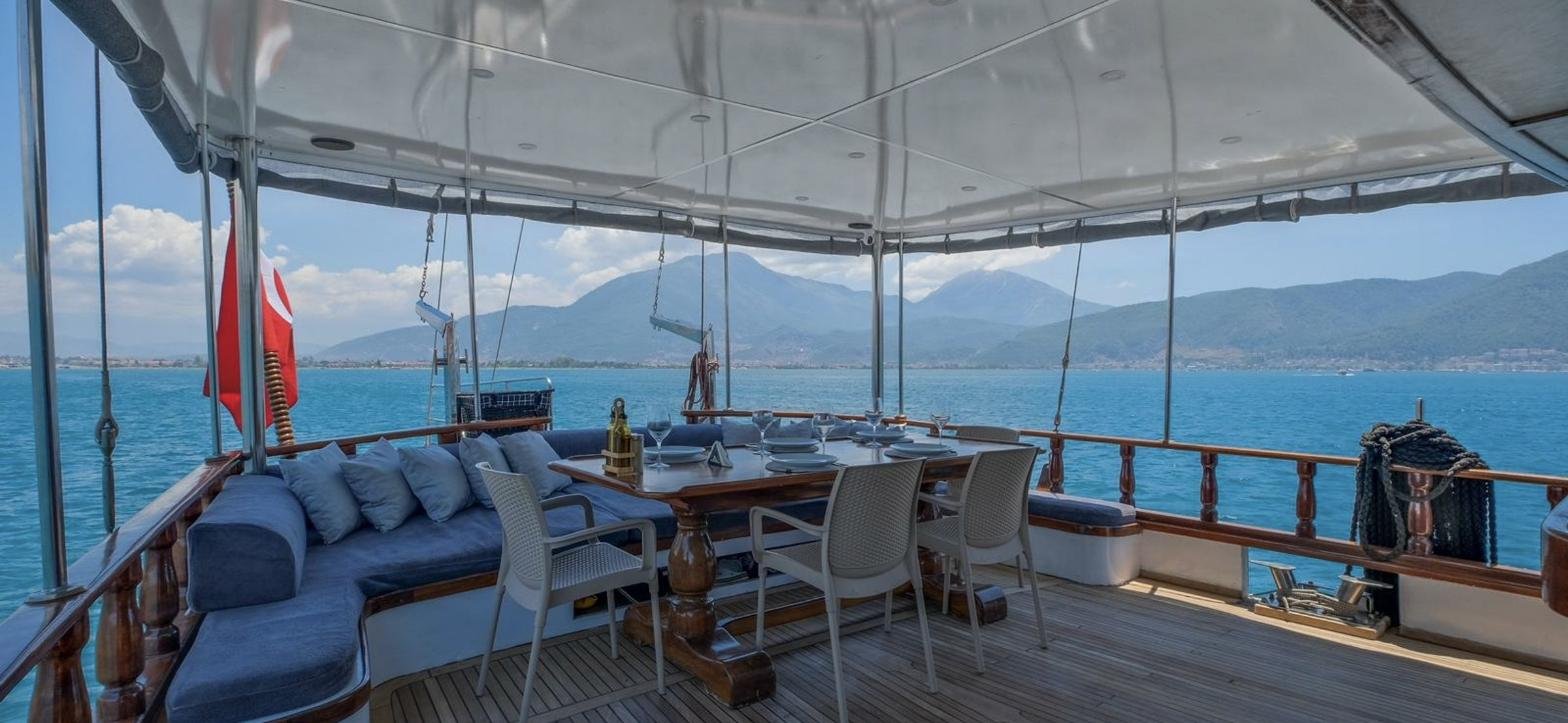 Göcek'te 28m gulette tentenin altında on kişilik kıç güverte yemek masası