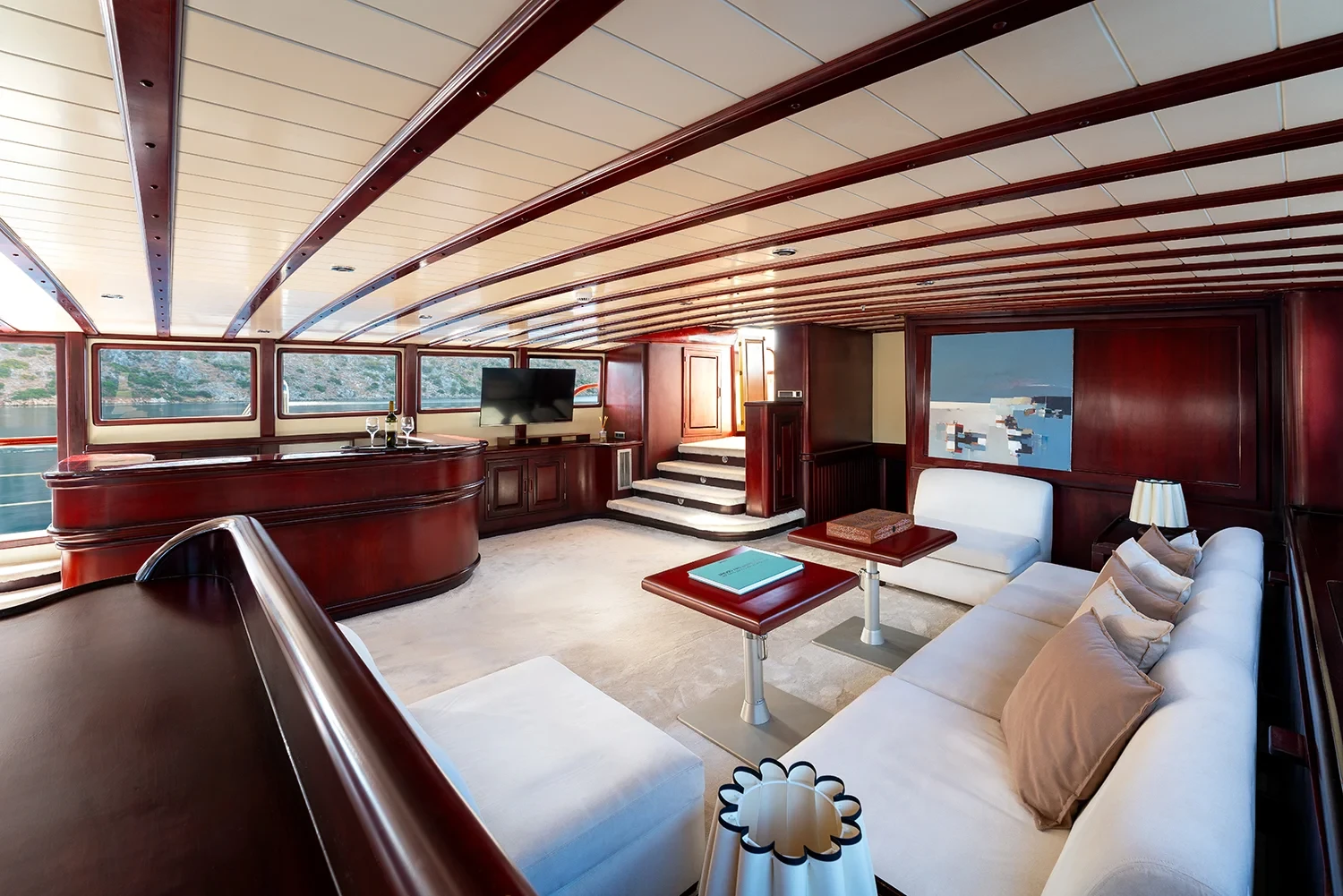 Saloon aboard a crewed motor yacht charter in Gocek with cream sofas and a mahogany coffee table