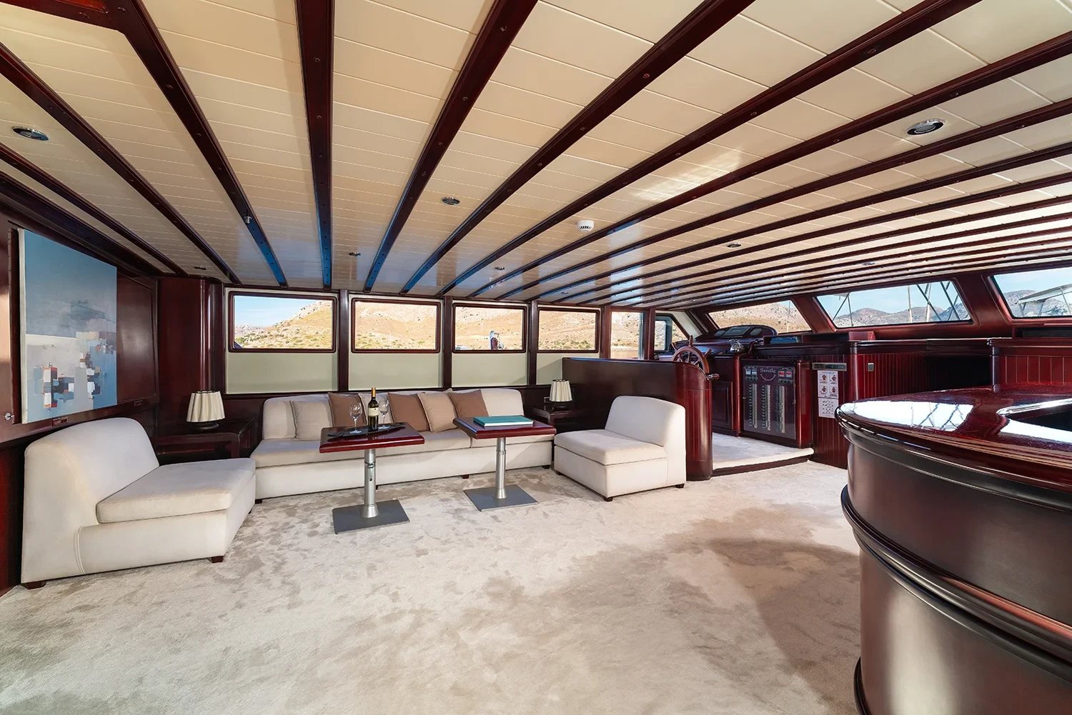 Saloon lounge aboard a crewed motor yacht charter in Gocek with cream sofas and a raised bar counter
