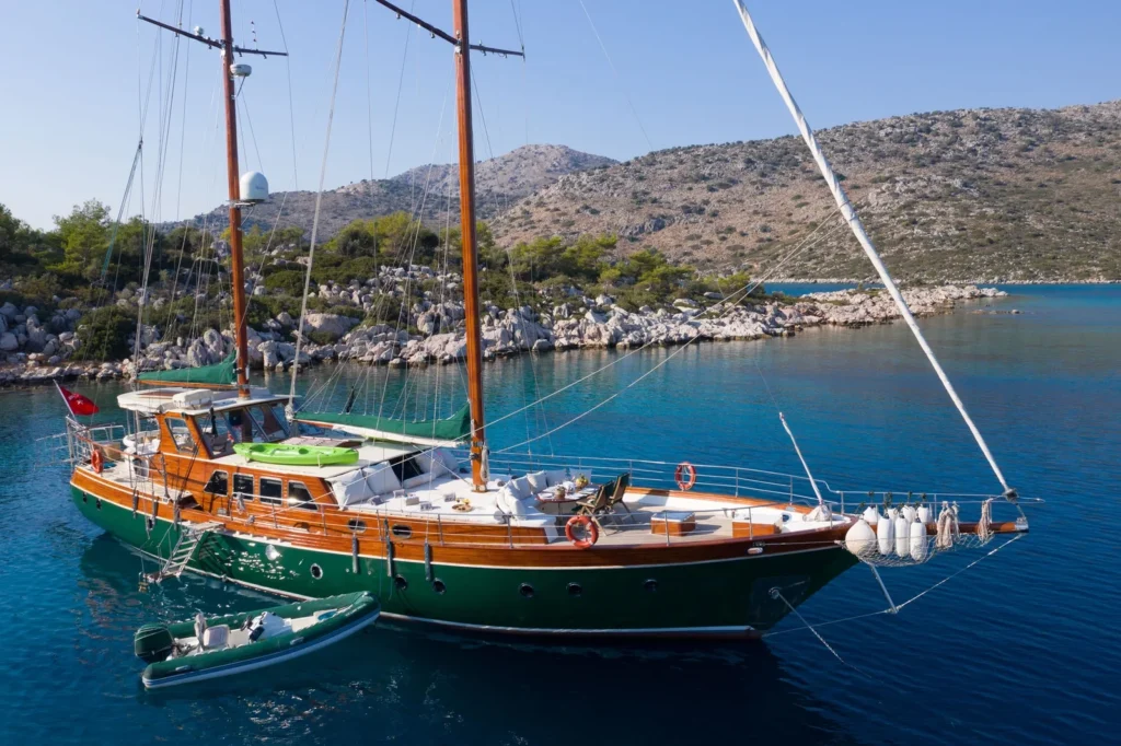 LF2308 23m deluxe gulet charter Rhodes at anchor turquoise cove hillside view