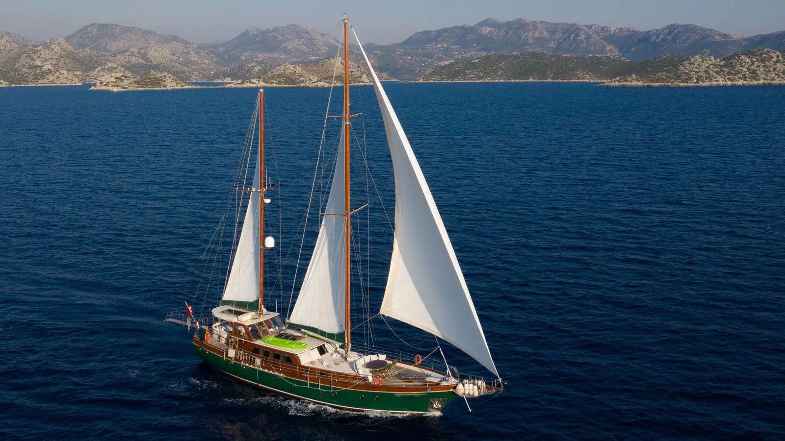LF2308 23m deluxe gulet charter Rhodes full sail mountain backdrop cruise