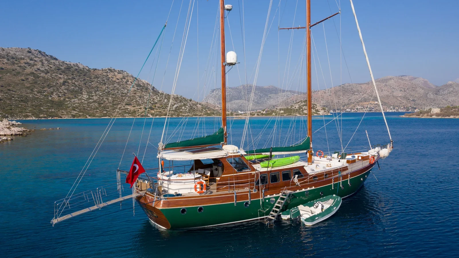 LF2308 23m deluxe gulet charter Rhodes stern to mooring rocky coastline