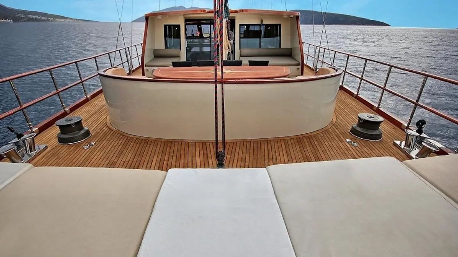 Aft lounge deck of the motor sailer with cushioned seating and sea view