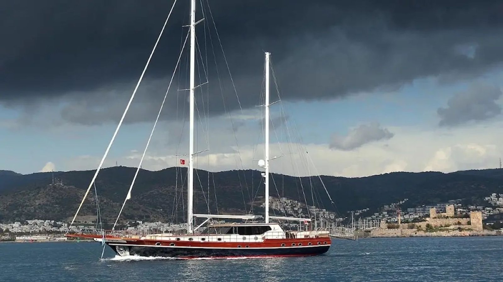 Twin-masted motor sailer under way with Bodrum Castle in the background