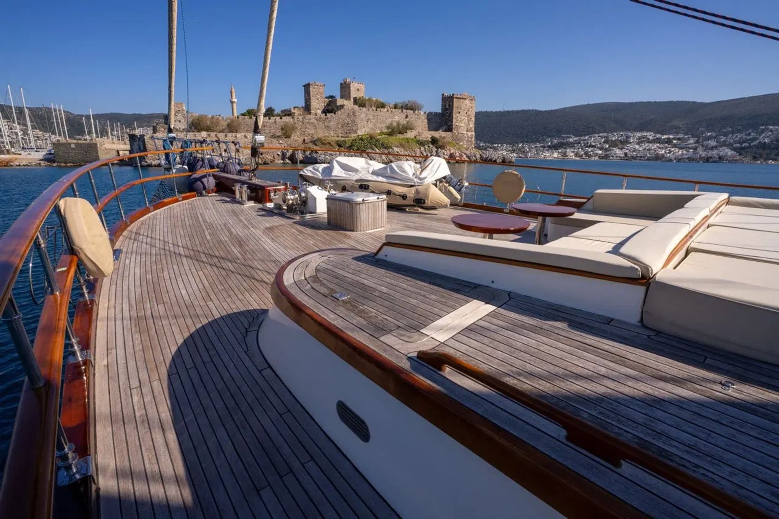 Side deck sunpads aboard the motor sailer with Bodrum Castle in the distance