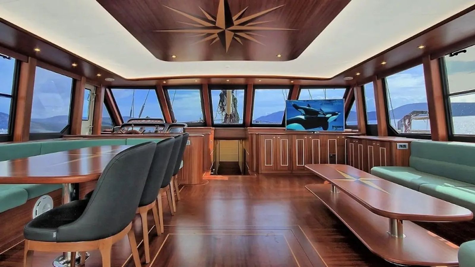 Wheelhouse dining area aboard the motor sailer with panoramic windows over Bodrum Bay