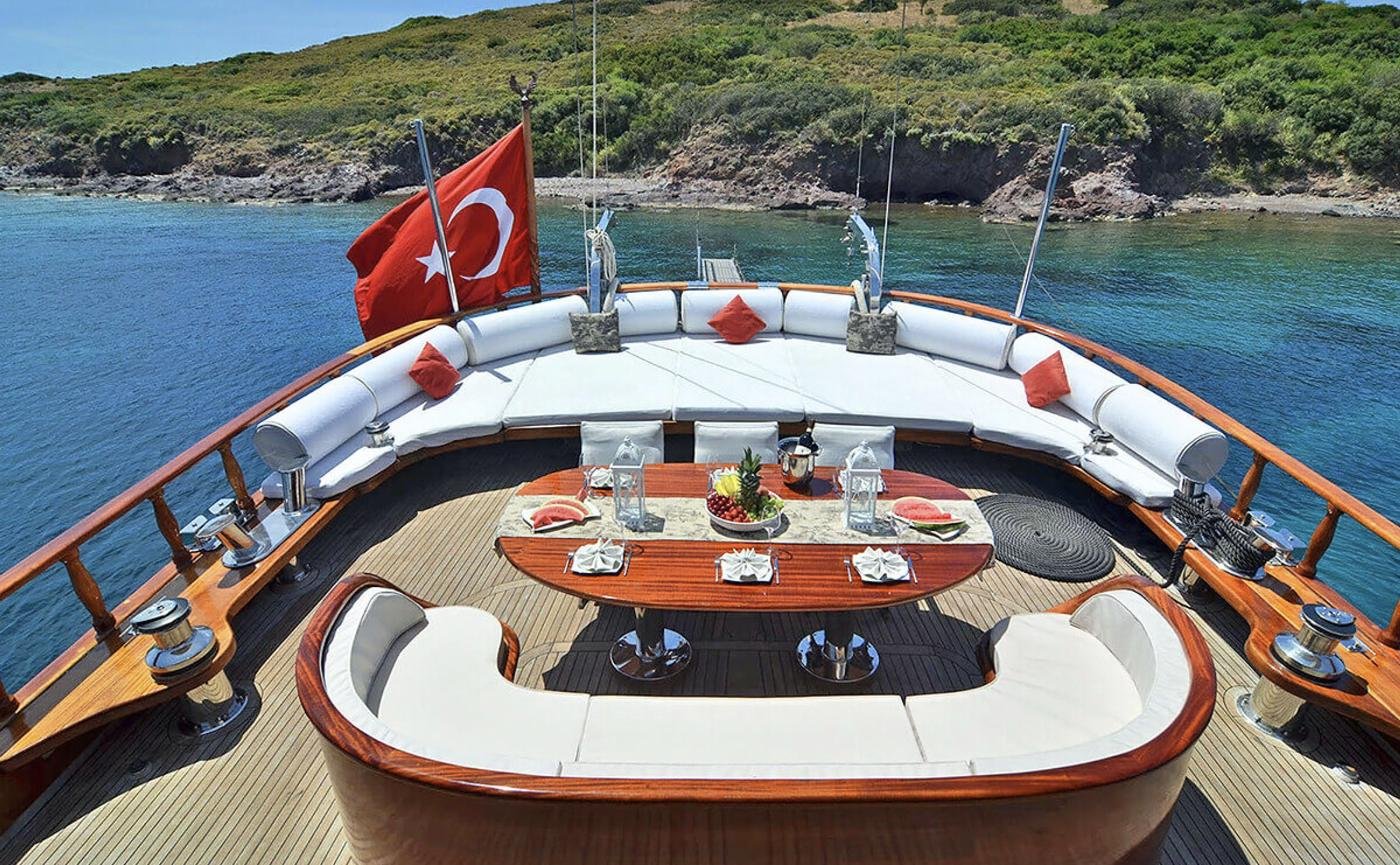 Elegant gulet charter Bodrum - aft deck dining table set with fruit and lanterns