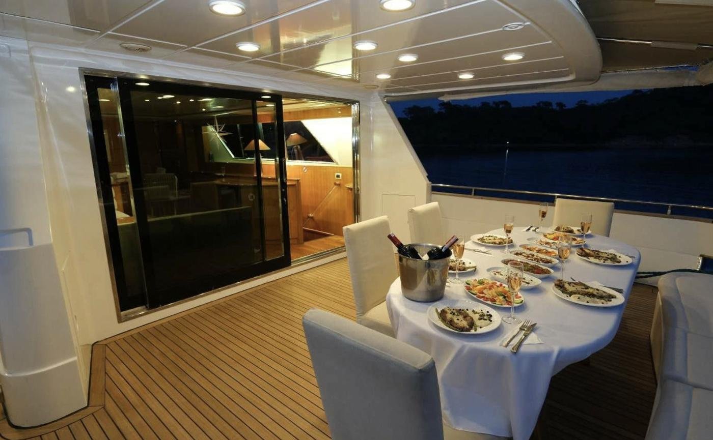 Falcon 80 charter Göcek — aft deck dining at dusk