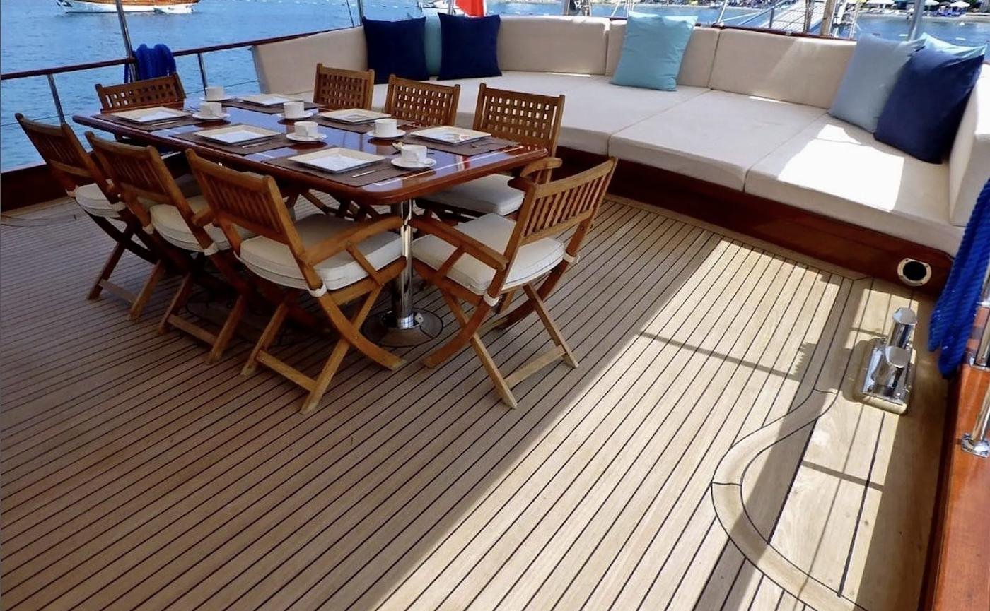 Shaded aft deck dining table set for ten on a family gulet charter Bodrum