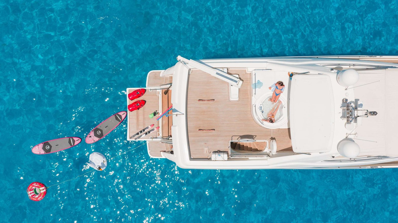 Aerial overhead of a Ferretti 830 Fly charter Rhodes showing the foredeck jacuzzi, sun pads and water toys alongside