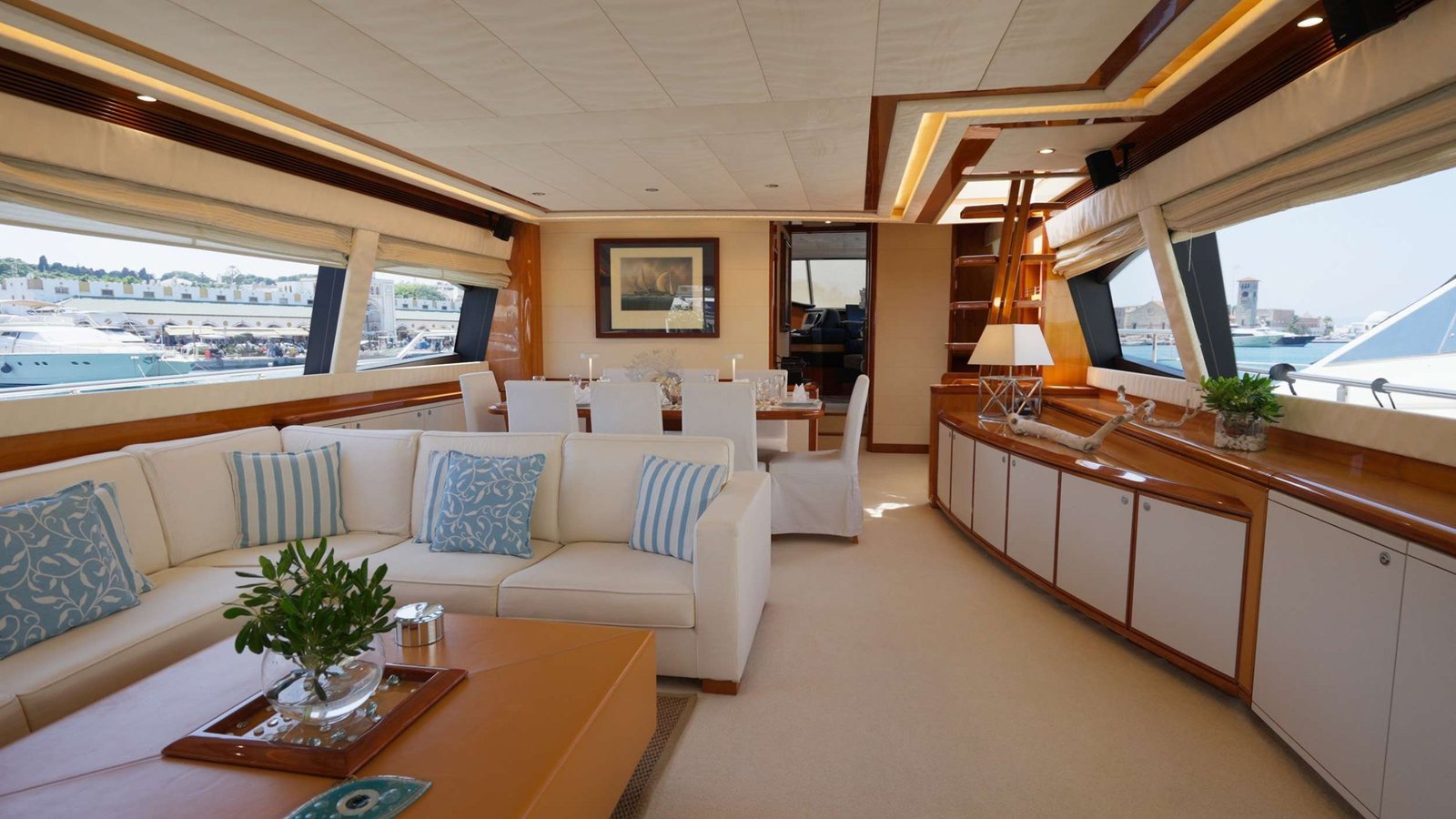 Main saloon of a Ferretti 830 Fly charter Rhodes with cream seating, cherry joinery and panoramic windows