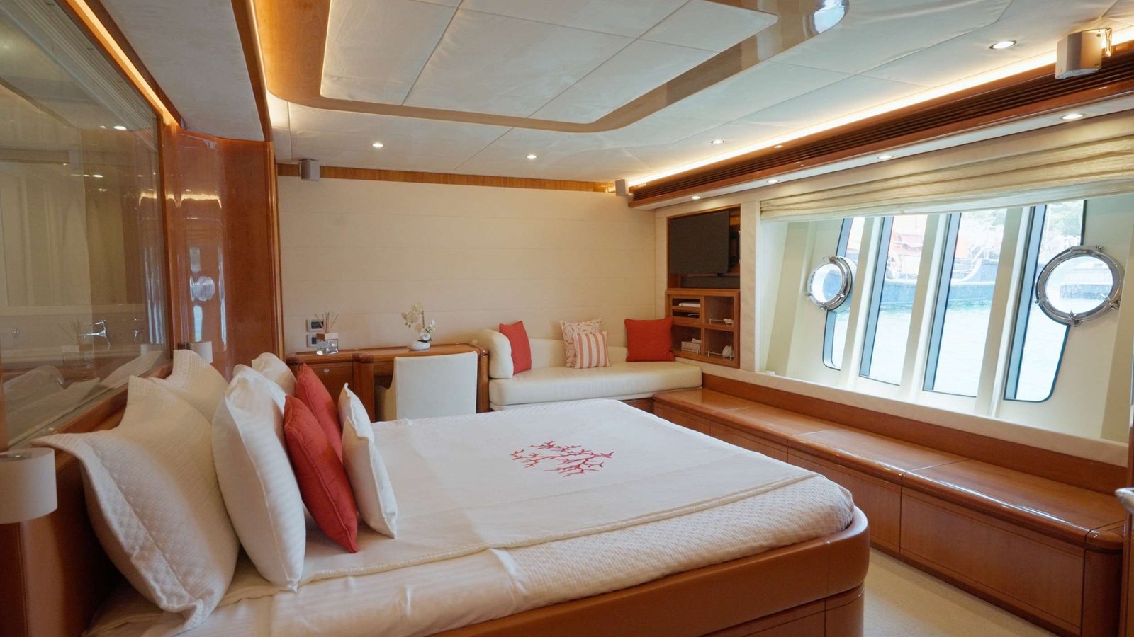 Full-beam master stateroom with king bed, private lounge and hull portholes aboard a Ferretti 830 Fly charter Rhodes