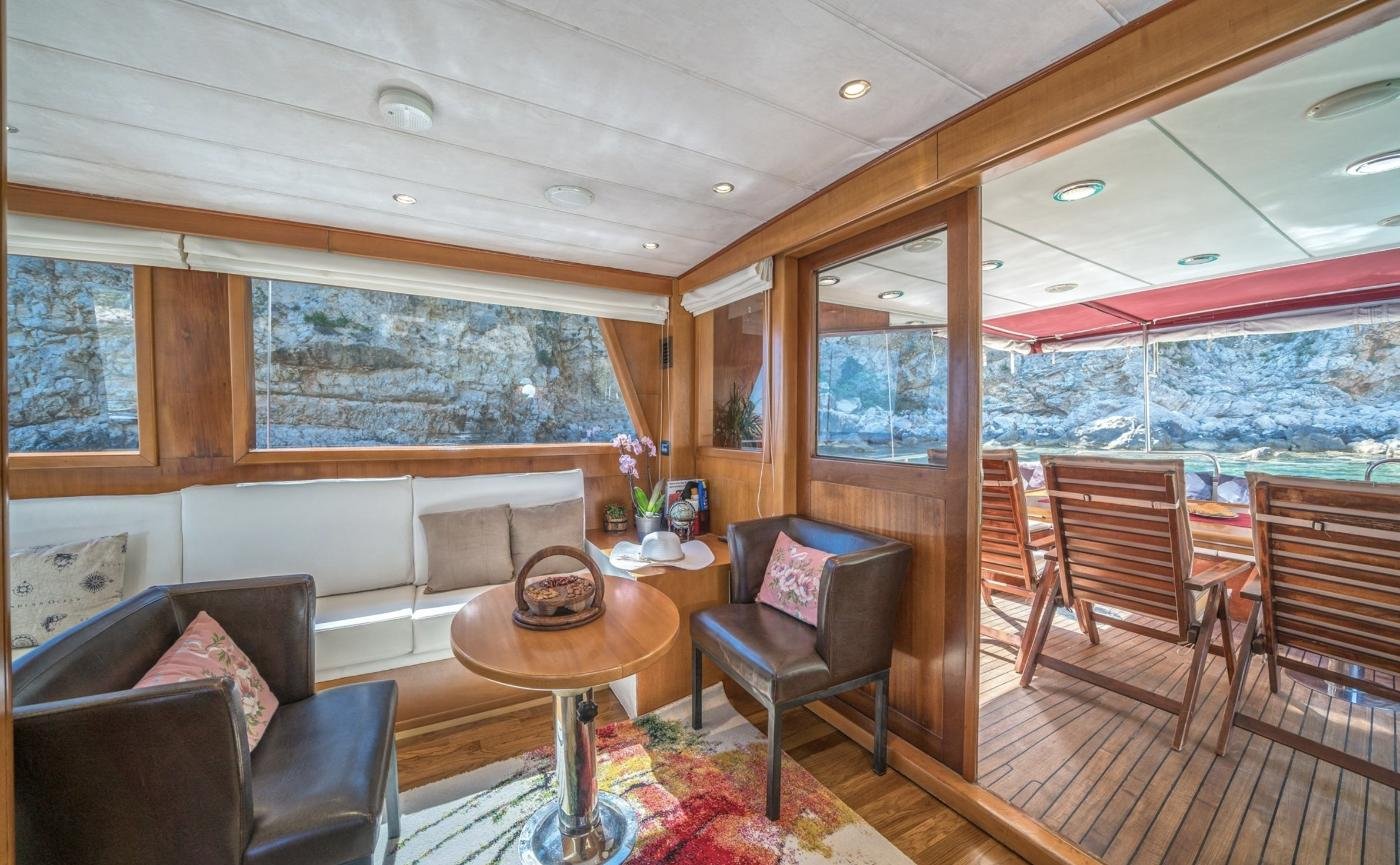 Dubrovnik kiralık guletin ahşap kaplamalı ve kıç güverteye bakan geniş pencereli salonu