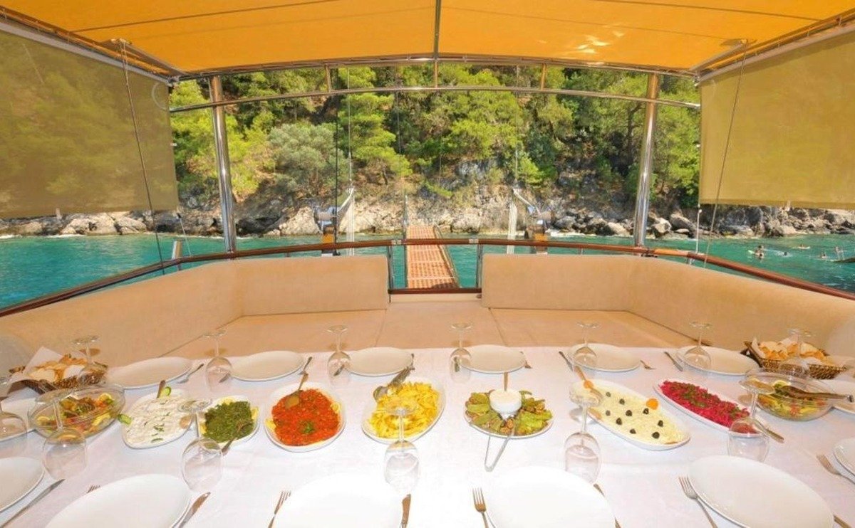 Meze ve deniz manzarasıyla gölgeli kıç güverte yemeği
